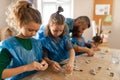 Group of little kids with teacher working with pottery clay during creative art and craft class at school. Royalty Free Stock Photo