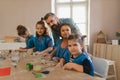 Group of little kids with teacher working with pottery clay during creative art and craft class at school. Royalty Free Stock Photo