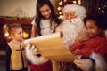 Group of little multi ethnic girls looking in Santa Claus with w