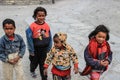 A group of little poor Nepalese children of boys and girls walk along a village street in the Himalayas. Poor children of Nepal