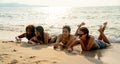 Group of lovely teen girls lie on the beach and enjoy to write funny words or draw something on sand during relax and happy on Royalty Free Stock Photo