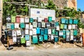 A Group of Mailboxes in Multiple Colors in a Neighborhood in a Village of Chania, Crete, Greece. An Old Castle Wall in Background.