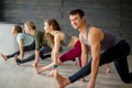 Yoga beginners exercising against grey wall, doing yoga or pilates posture.