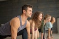 Yoga beginners exercising against grey wall, doing yoga or pilates posture.