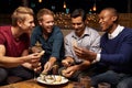 Group Of Male Friends Enjoying Night Out At Rooftop Bar Royalty Free Stock Photo