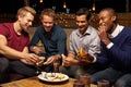 Group Of Male Friends Enjoying Night Out At Rooftop Bar Royalty Free Stock Photo