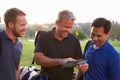 Group Of Male Golfers Marking Scorecard At End Of Round