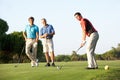 Group Of Male Golfers Teeing Off