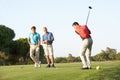 Group Of Male Golfers Teeing Off