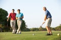 Group Of Male Golfers Teeing Off