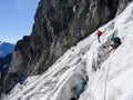 Group of male mountain climbers crossing a glacier on their way down from a high alpine peak