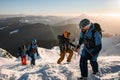 group of male tourists climbing up at snow-covered mountain trail against the backdrop of a beautiful winter mountain Royalty Free Stock Photo