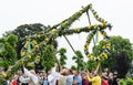 A group of male volunteers working on raising the maypole in a traditional manner at a midsummer celebration in Hagelbyparken, bot