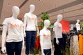 A group of mannequins in a boutique dressed in white t-shirts with the word `sale` printed in red on them