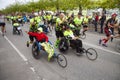 Group of marathon runners pushing running wheel chairs with disabled persons helping them fulfill the run.