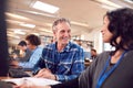 Group Of Mature Adult Students In Class Working At Computers In College Library