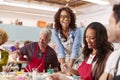 Group Of Mature Adults Attending Art Class In Community Centre With Teacher