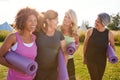 Group Of Mature Female Friends On Outdoor Yoga Retreat Walking Along Path Through Campsite Royalty Free Stock Photo