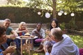 Group Of Mature Friends Enjoying Drinks In Backyard Together Royalty Free Stock Photo