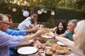 Group Of Mature Friends Enjoying Outdoor Meal In Backyard Royalty Free Stock Photo