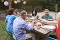 Group Of Mature Friends Enjoying Outdoor Meal In Backyard Royalty Free Stock Photo