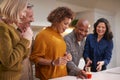 Group Of Mature Friends Meeting At Home To Celebrate Womans Birthday With Cake Royalty Free Stock Photo