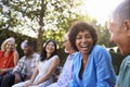 Group Of Mature Friends Socializing In Backyard Together