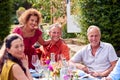 Group Of Mature Friends Talking Around Table At Summer Dinner Party In Garden At Home Royalty Free Stock Photo