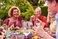 Group Of Mature Friends Talking Around Table At Summer Dinner Party In Garden At Home Royalty Free Stock Photo