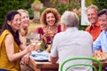 Group Of Mature Friends Talking Around Table At Summer Dinner Party In Garden At Home Royalty Free Stock Photo