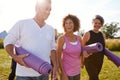 Group Of Mature Men And Women With Exercise Mats At End Of Outdoor Yoga Class Royalty Free Stock Photo