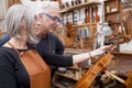 Group of mature violin maker in pose Royalty Free Stock Photo