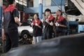 Group of mechanic workers is cheerful with finished repair work at car garage.