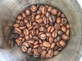 Group of medium roasted coffee bean in stainless steel cup