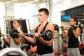 Group of men with barbells in gym