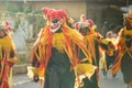 Group of men in clown mask walks under rain by city street at dominican carnival