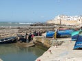 A group of men haul a boat in the fishing port of Essaouira, Morocco