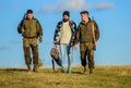 Group men hunters or gamekeepers nature background blue sky. Guys gathered for hunting. Men carry hunting rifles