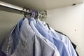 A group of men`s shirts in a white wardrobe hung with hangers Royalty Free Stock Photo