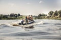 Group of men sailing on motor boat by river in summer day to the camping site during hunting season Royalty Free Stock Photo