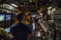 A group of men standing inside a busy control room on an aircraft carrier, An aircraft carrier interior bustling with activity as Royalty Free Stock Photo