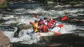 Group of men and women, enjoy water rafting activity at river. Royalty Free Stock Photo