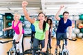 Group of men and women spinning on fitness bikes in gym Royalty Free Stock Photo