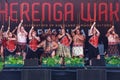 Maori men and women perform haka on stage