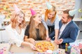 A group of men and women working in the office, eating pizza in a festive mood. Royalty Free Stock Photo