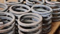 Group of metal springs of shock absorbers on wooden palete. Spare parts of heavy industrial machinery