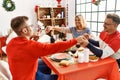 Group of middle age caucasian family having christmas dinner and praying for food sitting on the table at home Royalty Free Stock Photo