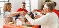 Group of middle age caucasian family having christmas dinner and praying for food sitting on the table at home Royalty Free Stock Photo