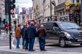 Group Of Middle Aged Men Standing At Traffic Lights In City Of Westminster London UK