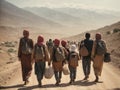 A group of migrants with children walk along a dusty road.